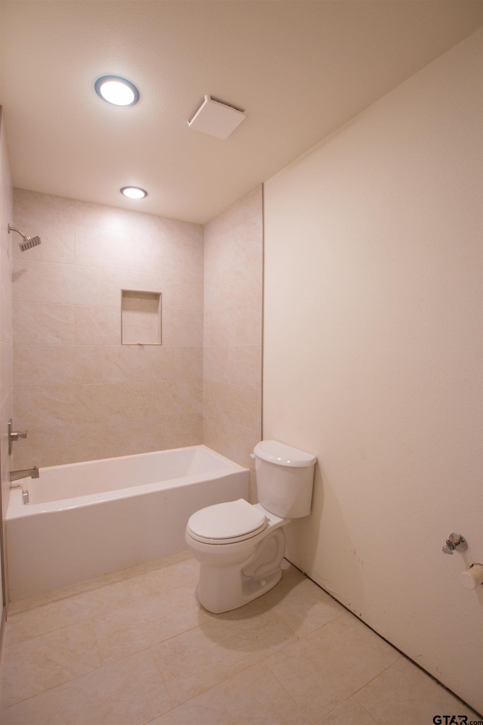 1112 Park Street Tyler, TX 75702 - Photo 9 of 26 a bathroom with a toilet and a bathtub