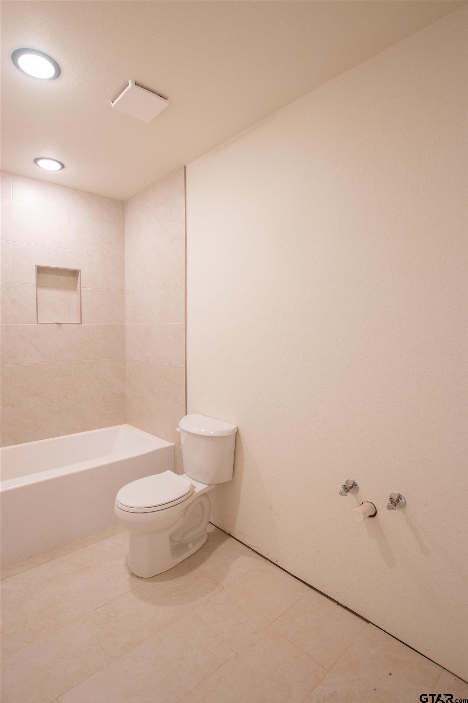1112 Park Street Tyler, TX 75702 - Photo 10 of 26 a bathroom with a toilet and a bathtub