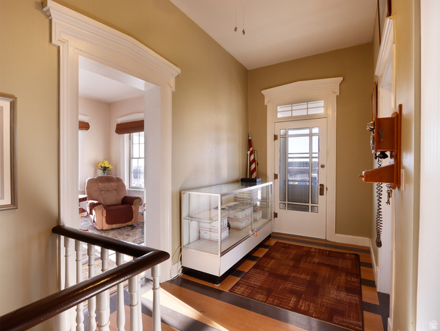 155 West Center Street Fillmore, UT 84631 - Photo 52 of 86 Hallway featuring wood-finish flooring with dark contrasting border, white door casing, and a white front door with transom window