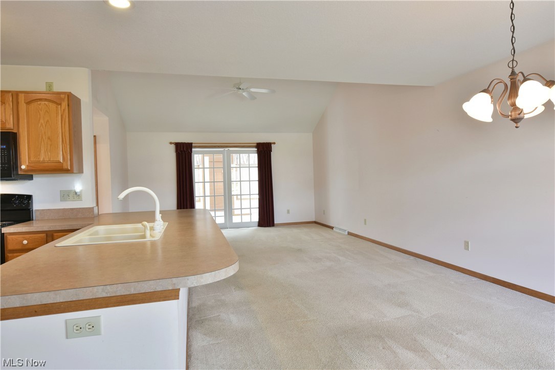 2033 East River Road, Unit 11 Newton Falls, OH 44444 - Photo 6 of 35 Kitchen featuring vaulted ceiling, light carpet, range, and ceiling fan