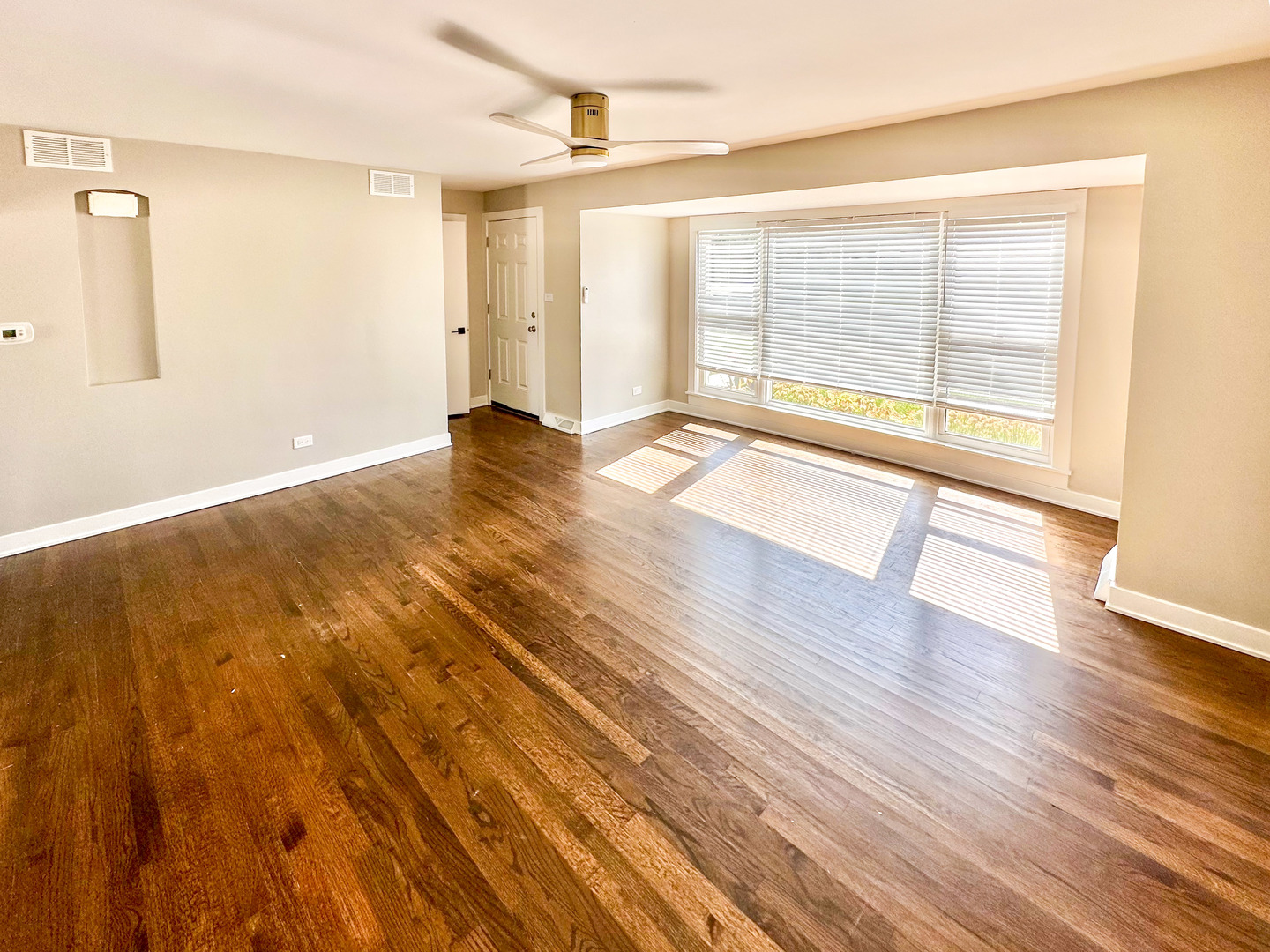 8150 West Winnemac Avenue Norridge, IL 60706 - Photo 4 of 14 a view of an empty room with wooden floor and a window