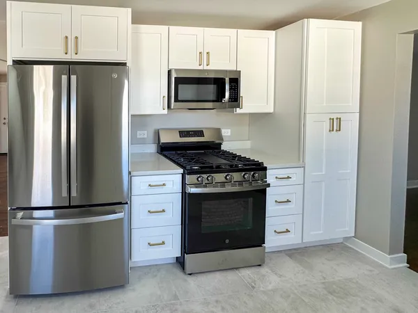 a kitchen with stainless steel appliances a refrigerator stove and microwave