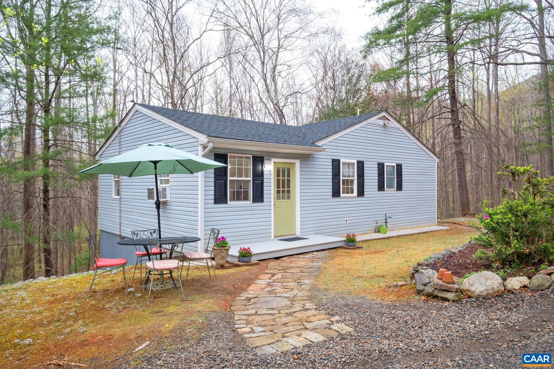 115 Circle Road Stanardsville, VA 22973 - Photo 1 of 28 a backyard of a house with table and chairs under an umbrella