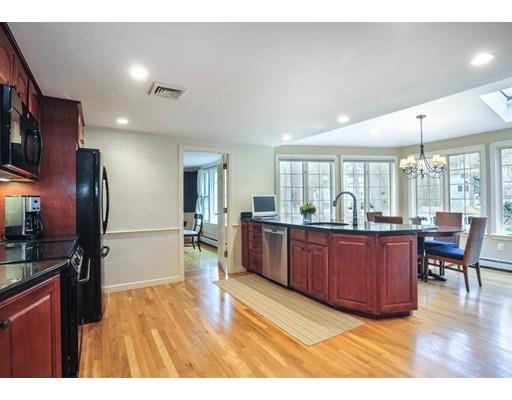 3 Flintlock Circle Hingham, MA 02043 - Photo 10 of 23 a kitchen with stainless steel appliances kitchen island granite countertop a refrigerator a stove a sink dishwasher with a dining table and chairs with wooden floor