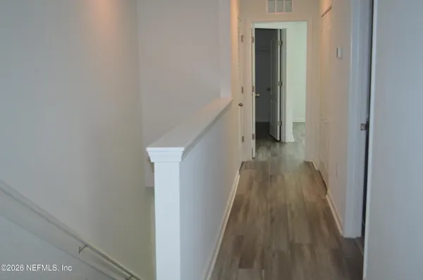 a view of entryway and hall with wooden floor