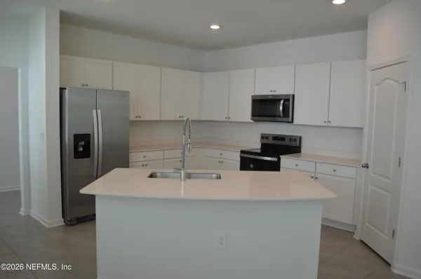 a large kitchen with a large window and stainless steel appliances