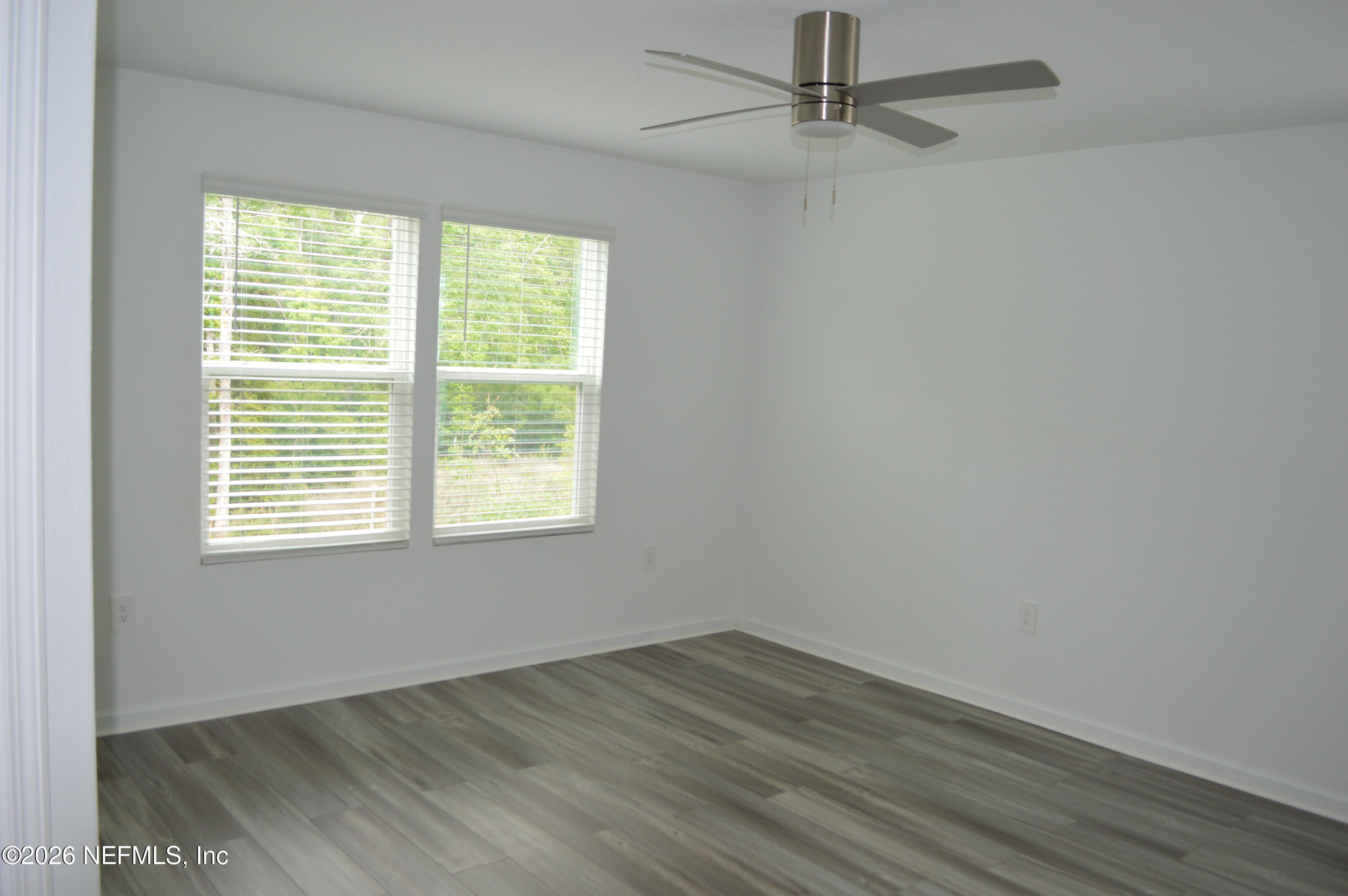 155 Seaport Breeze Road St. Augustine, FL 32095 - Photo 8 of 29 an empty room with wooden floor fan and windows