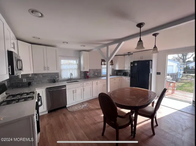 a kitchen with a dining table chairs and refrigerator