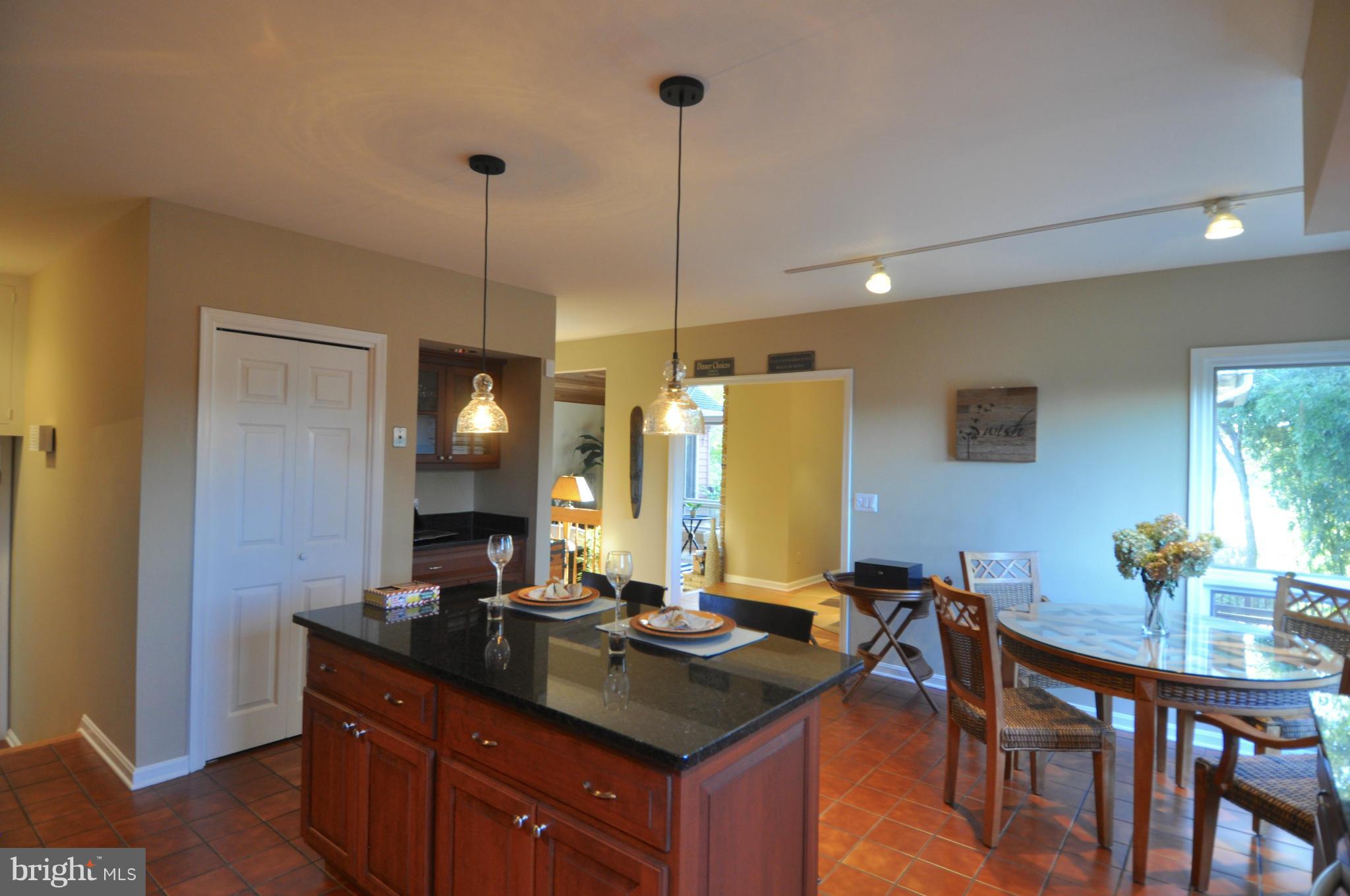 1890 Hidden Point Road Annapolis, MD 21409 - Photo 11 of 30 a kitchen with a kitchen island a stove a sink a dining table and chairs
