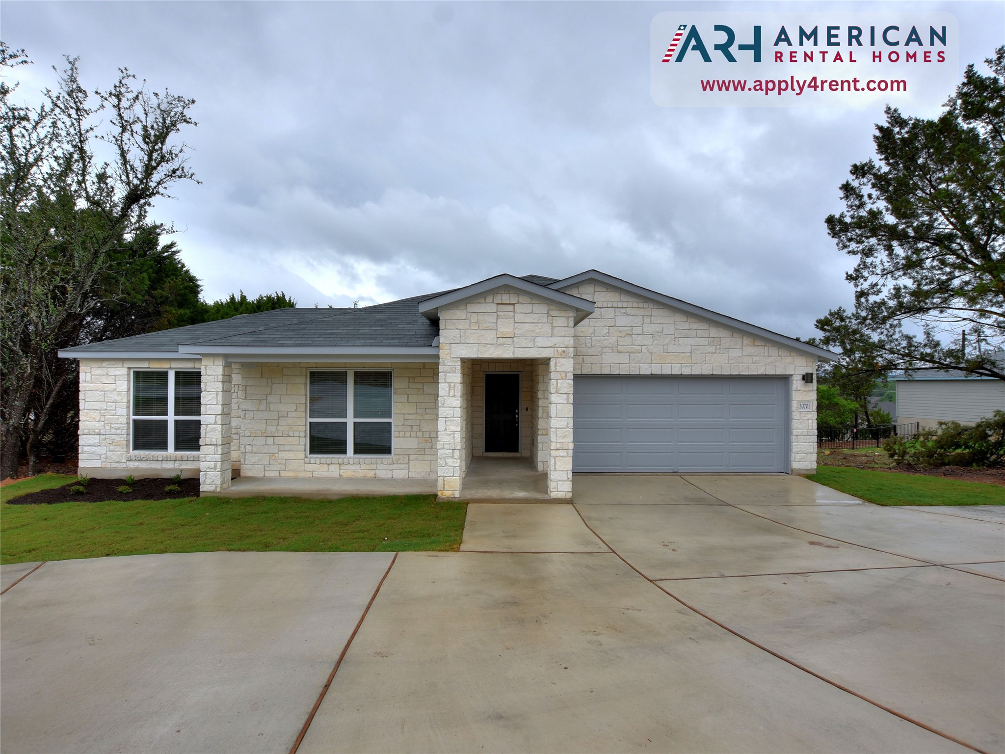 20701 Boggy Ford Road Lago Vista, TX 78645 - Photo 1 of 40 Ranch-style house featuring stone siding, a garage, a front yard, concrete driveway, and roof with shingles