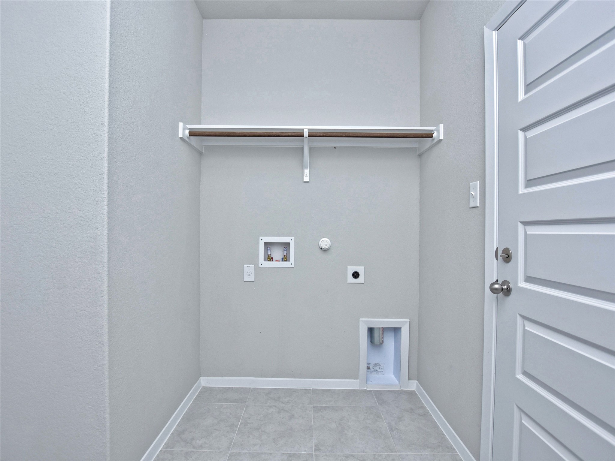 20701 Boggy Ford Road Lago Vista, TX 78645 - Photo 12 of 40 Laundry room featuring hookup for a gas dryer, washer hookup, electric dryer hookup, and light tile patterned floors