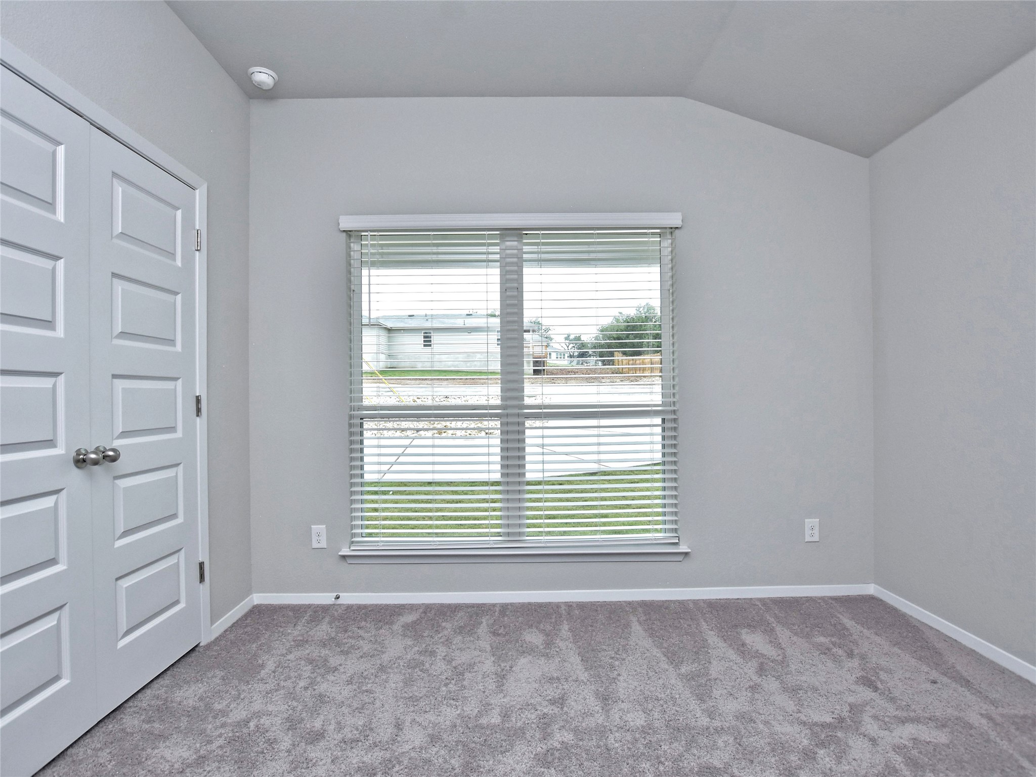 20701 Boggy Ford Road Lago Vista, TX 78645 - Photo 23 of 40 Spare room featuring light colored carpet and vaulted ceiling