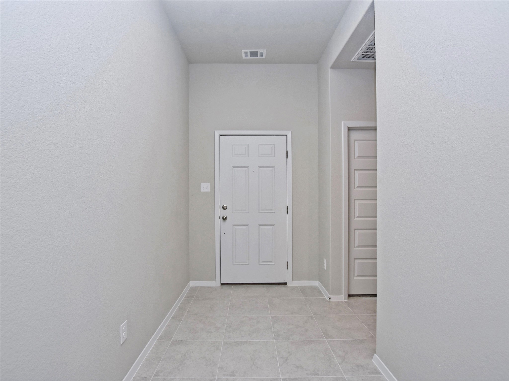 20701 Boggy Ford Road Lago Vista, TX 78645 - Photo 5 of 40 Doorway to outside featuring tile patterned flooring and a textured wall