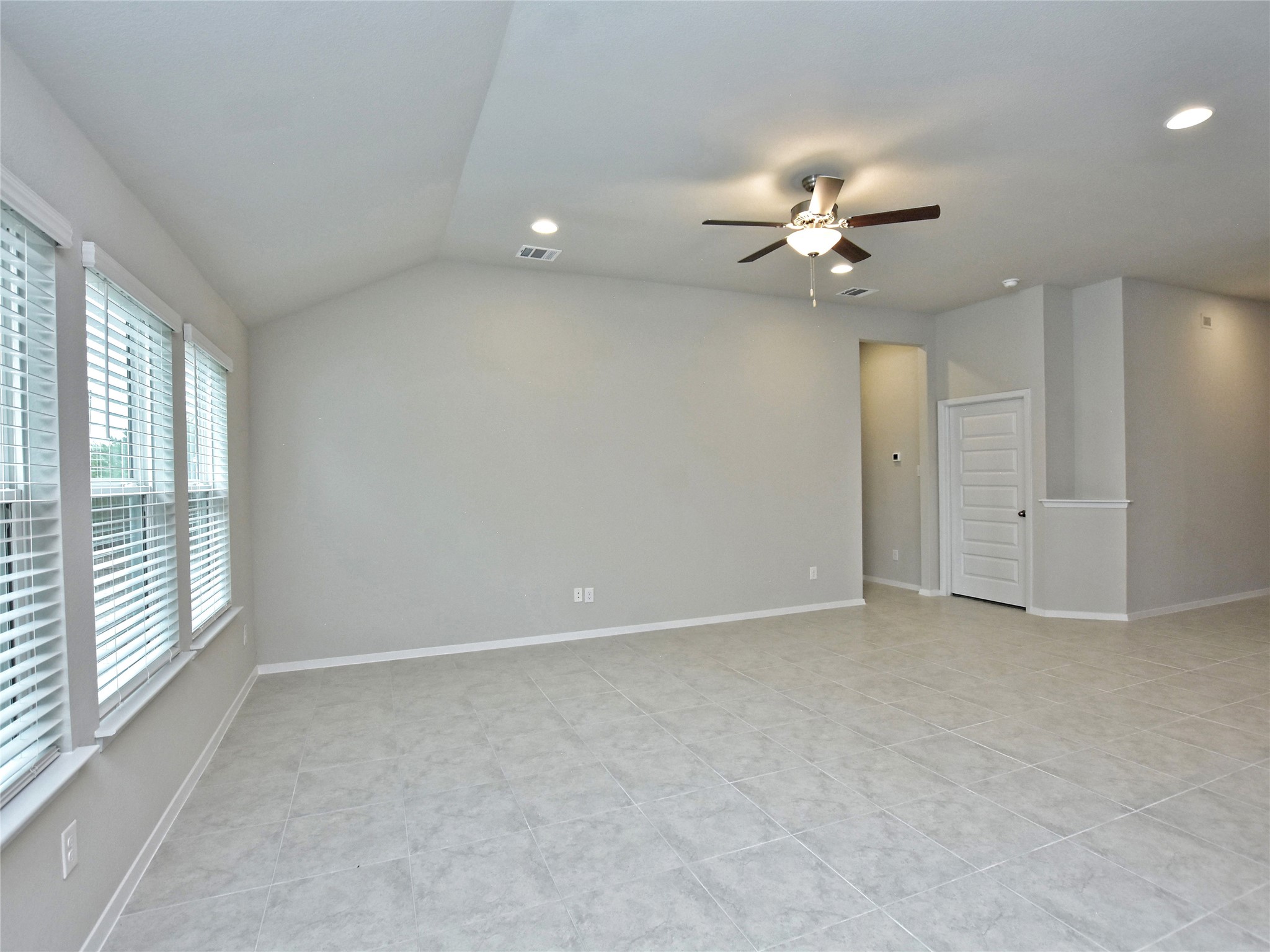 20701 Boggy Ford Road Lago Vista, TX 78645 - Photo 7 of 40 Unfurnished room featuring lofted ceiling, a ceiling fan, recessed lighting, and light tile patterned flooring