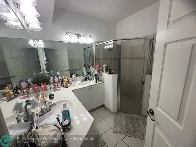 a bathroom with a sink mirror and shower
