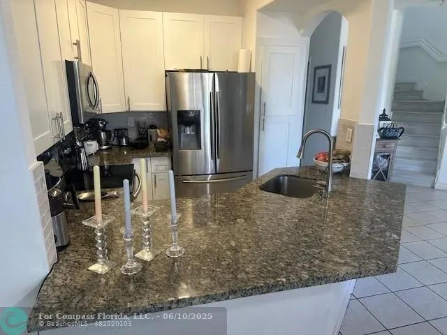 a kitchen with kitchen island a sink a counter appliances and cabinets