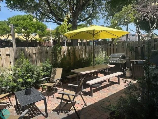 a view of backyard with outdoor seating and trees