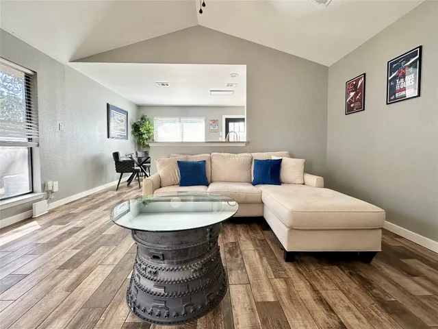 a living room with furniture and a wooden floor