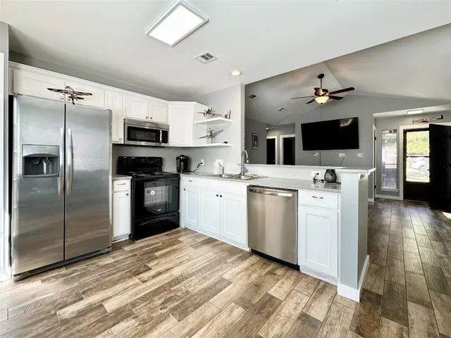 a kitchen with stainless steel appliances a refrigerator sink and microwave