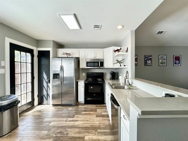 a kitchen with stainless steel appliances granite countertop a refrigerator and a stove top oven