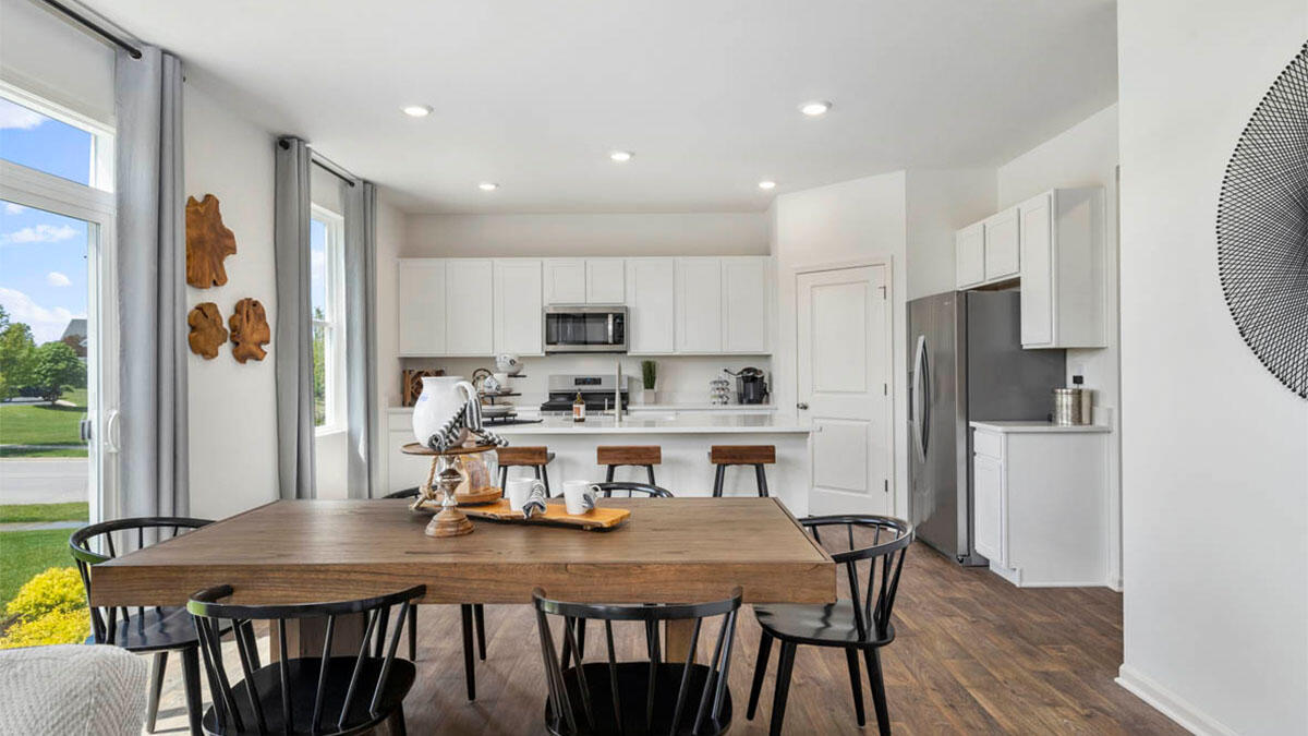 10365 Blaine Street Crown Point, IN 46307 - Photo 38 of 51 a kitchen with refrigerator dining table and chairs