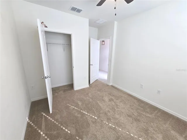 a view of a big room with closet and windows