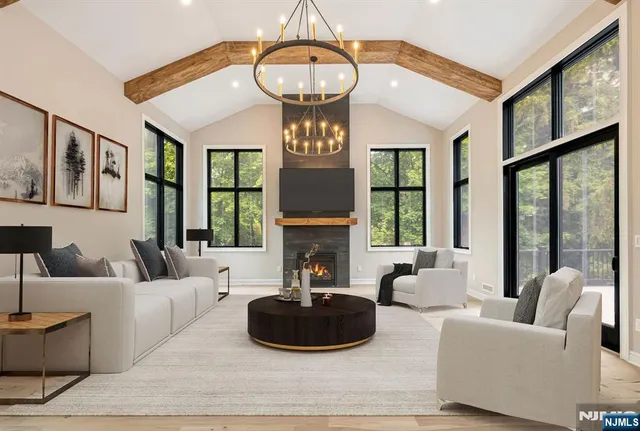 a living room with furniture a fireplace and large windows