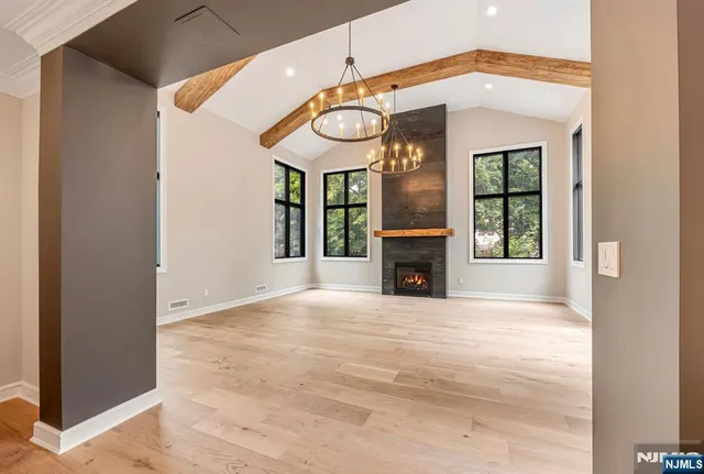 a view of an empty room with a fireplace and a window