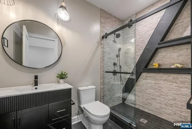 a bathroom with a sink a toilet and a mirror