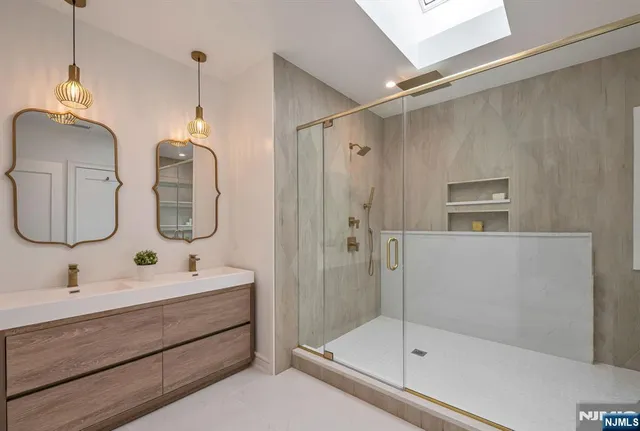 a bathroom with a double vanity sink mirror and shower