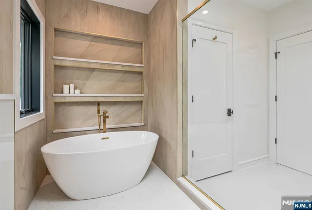 a white bath tub sitting next to a shower