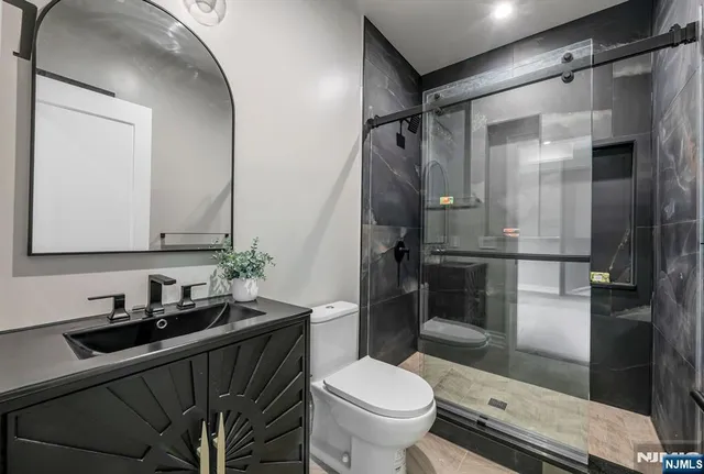 a bathroom with a sink a toilet and shower