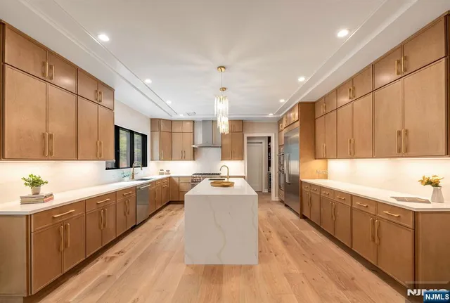a large kitchen with stainless steel appliances lots of counter space and wooden floor