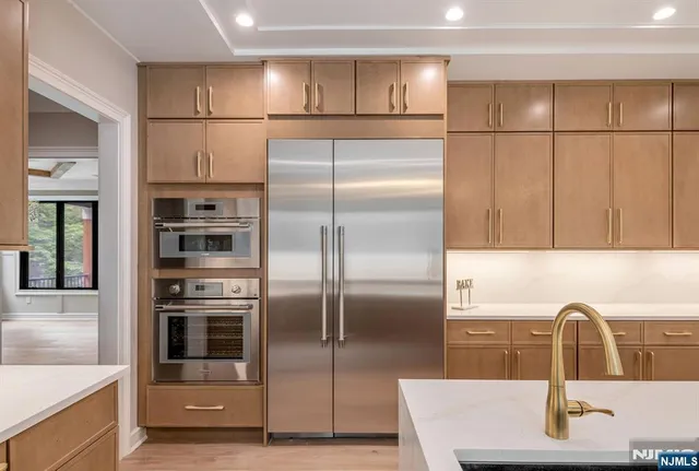 a kitchen with stainless steel appliances granite countertop a refrigerator and a sink
