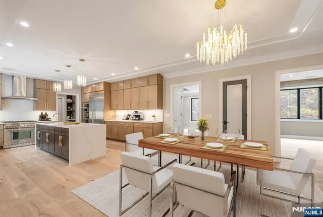 a kitchen with a dining table chairs stainless steel appliances and cabinets