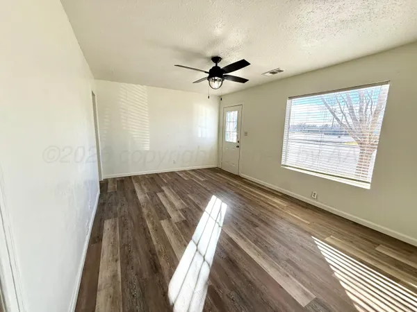 wooden floor in an empty room with a window