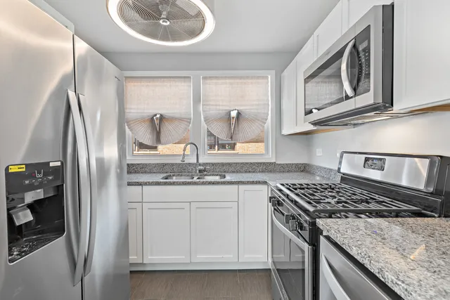 a kitchen with stainless steel appliances granite countertop a sink stove and refrigerator