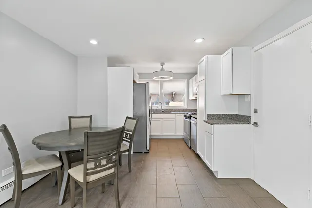 a kitchen with granite countertop a sink cabinets and stainless steel appliances
