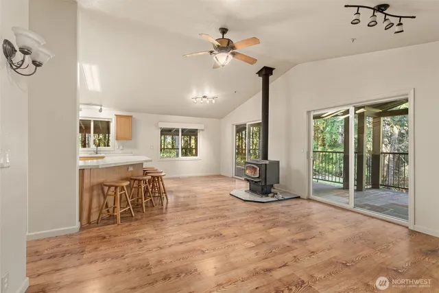 a dining hall with stainless steel appliances granite countertop a stove a sink a dining table and chairs with wooden floor