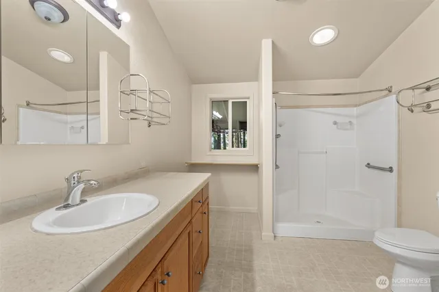 an empty room with a window and chandelier fan