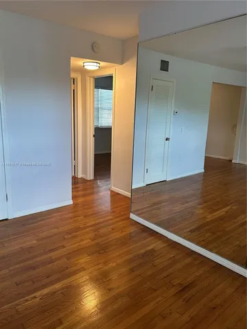 a view of a room with wooden floor