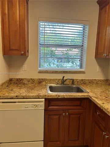 a kitchen with granite countertop cabinets sink and window