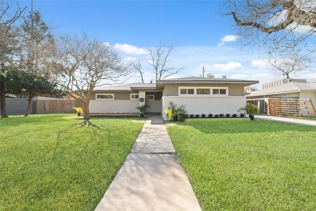 a front view of a house with a garden and yard