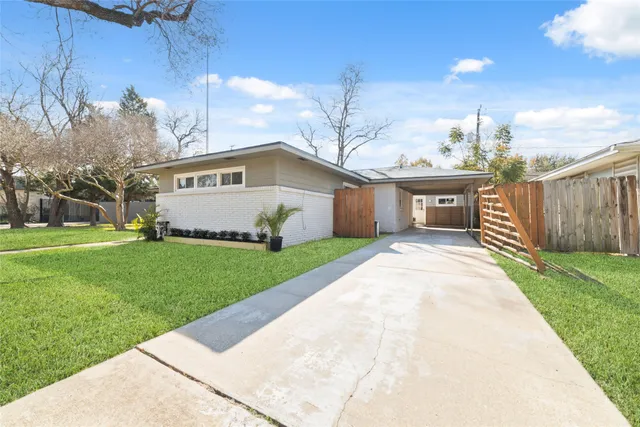 a front view of a house with a garden and yard