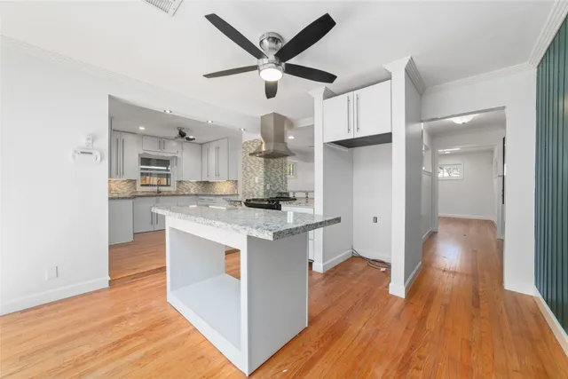 a large kitchen with stainless steel appliances granite countertop a stove and a refrigerator