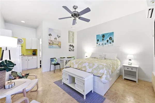 a spacious bedroom with a bed a couch and a painting on the wall