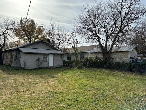 a view of a house with a garden and trees