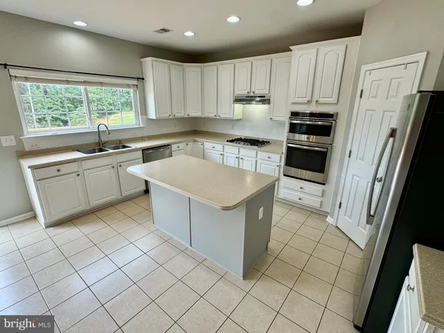a kitchen with a stove sink and refrigerator