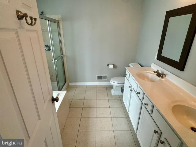 a bathroom with a sink a toilet a mirror and shower