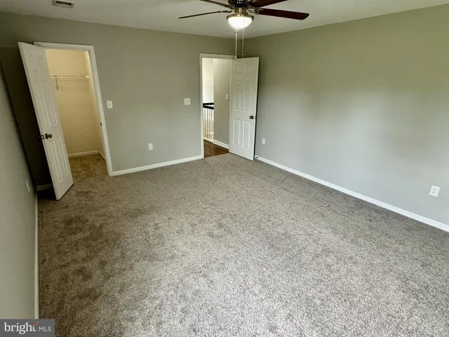 a view of a livingroom with a chandelier fan and a window